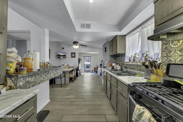 kitchen featuring wood finish floors, visible vents, a ceiling fan, a sink, and under cabinet range hood