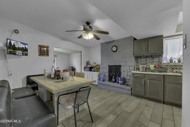 living room featuring wood finish floors, a ceiling fan, and a fireplace