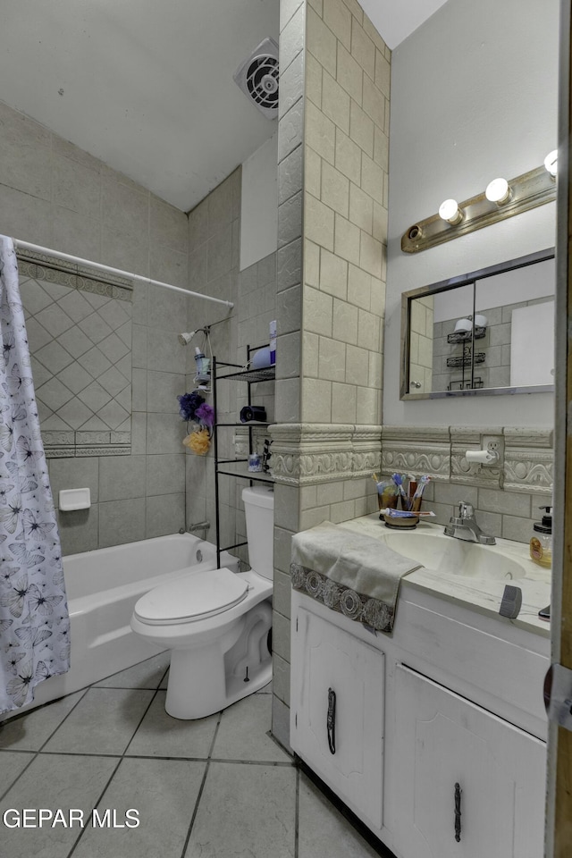 bathroom featuring tile patterned floors, visible vents, toilet, shower / bath combo, and tile walls