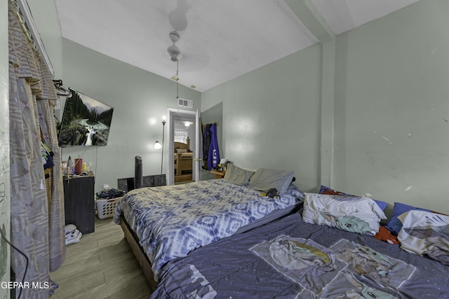 bedroom featuring a ceiling fan, wood finished floors, and visible vents