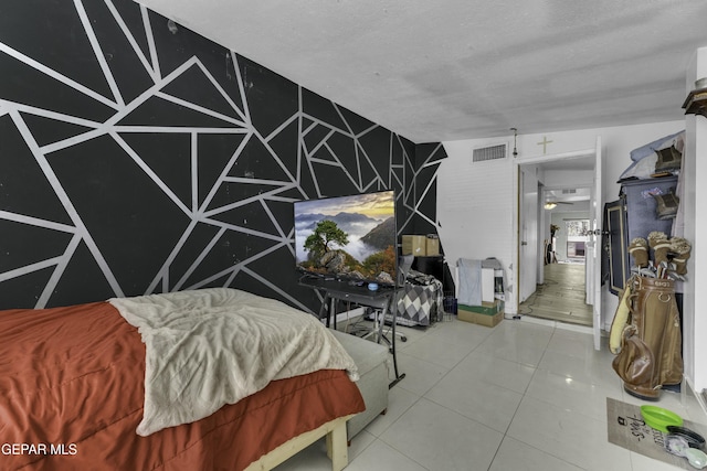 bedroom featuring tile patterned floors, visible vents, and a textured ceiling