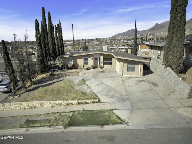 view of front of property featuring concrete driveway, brick siding, and a mountain view