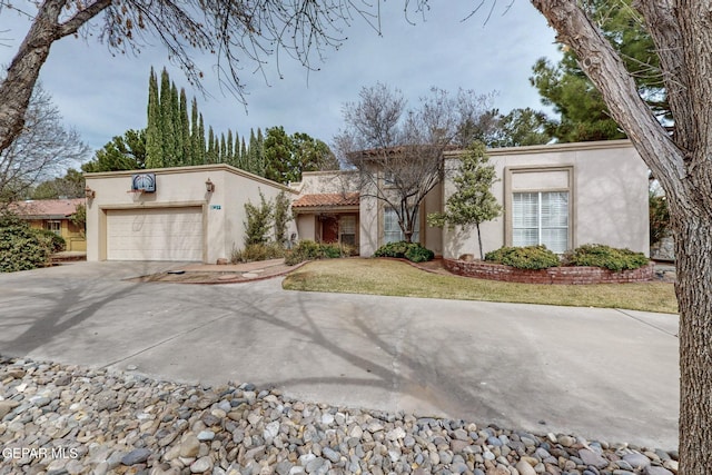 view of front of home with stucco siding, an attached garage, driveway, and a front yard