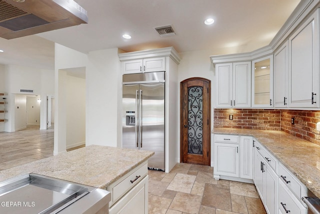 kitchen featuring visible vents, stainless steel built in refrigerator, backsplash, recessed lighting, and light stone countertops