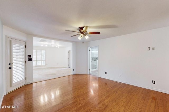 empty room featuring light wood-style flooring, baseboards, and ceiling fan