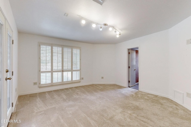 carpeted spare room featuring baseboards