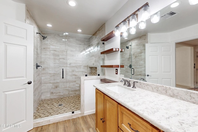 full bath featuring visible vents, a shower stall, recessed lighting, wood finished floors, and vanity