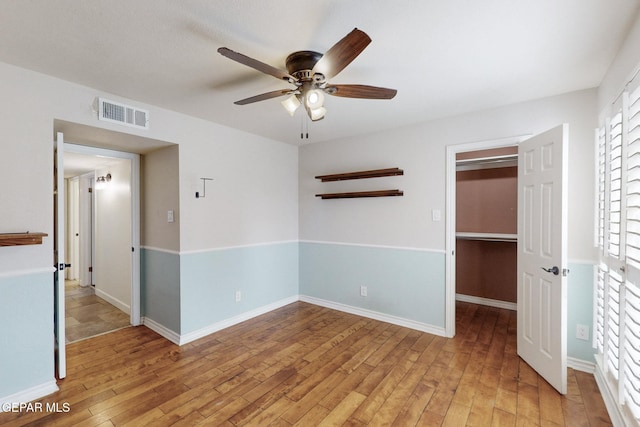 unfurnished room with light wood-type flooring, baseboards, visible vents, and ceiling fan