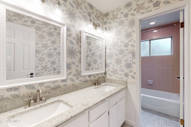 full bathroom featuring double vanity, tile patterned flooring, wallpapered walls, and a sink