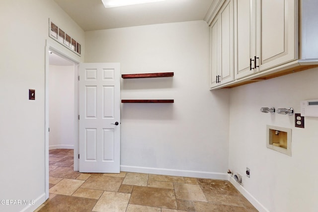 washroom featuring washer hookup, stone tile floors, cabinet space, and baseboards