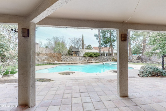 view of pool featuring fence, a pool with connected hot tub, and a patio area