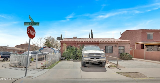 view of front of house featuring a tiled roof and fence