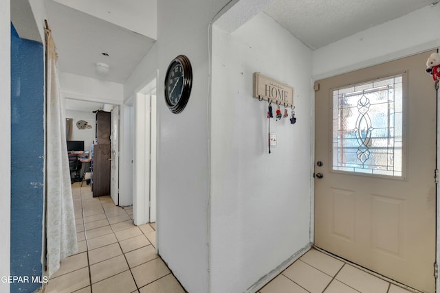 entrance foyer featuring light tile patterned floors and a textured ceiling