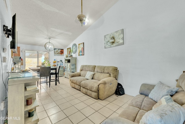 living area with light tile patterned floors, an inviting chandelier, a textured ceiling, and lofted ceiling