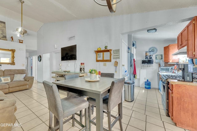 dining area with light tile patterned floors, visible vents, and lofted ceiling