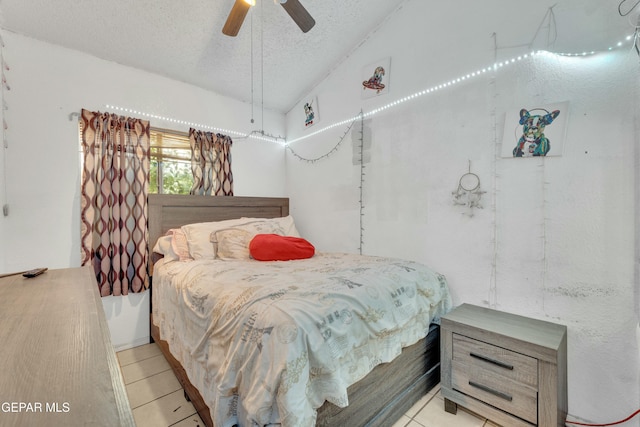 tiled bedroom with a textured ceiling, a ceiling fan, and vaulted ceiling