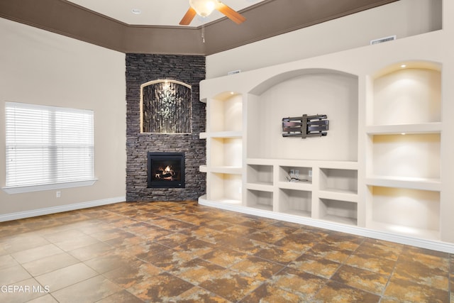 unfurnished living room with baseboards, built in shelves, a fireplace, and ceiling fan