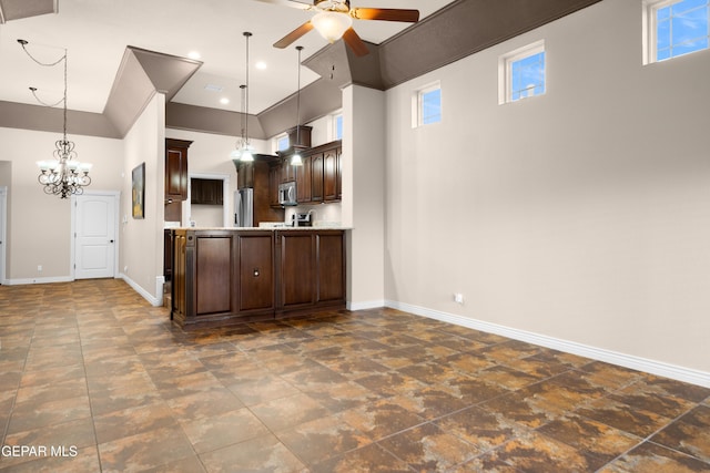 kitchen with ceiling fan with notable chandelier, appliances with stainless steel finishes, light countertops, baseboards, and dark brown cabinets