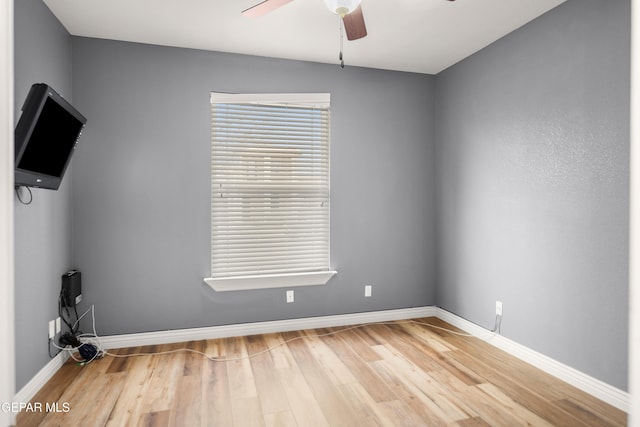 empty room with baseboards, light wood-style floors, and ceiling fan