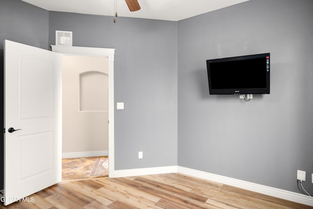 interior space with baseboards, wood finished floors, visible vents, and ceiling fan