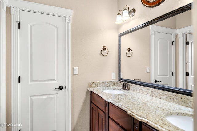 bathroom featuring a sink and double vanity