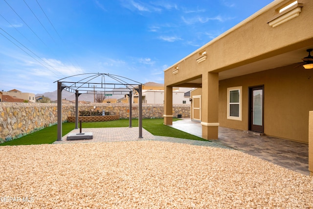 view of yard featuring a ceiling fan, a gazebo, a fenced backyard, and a patio