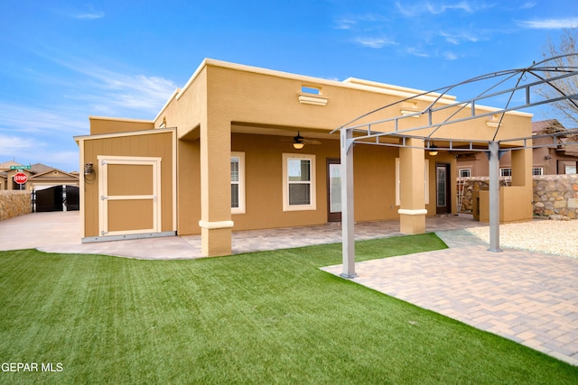 back of house with a patio, a ceiling fan, fence, a yard, and stucco siding