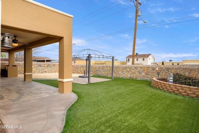 view of yard with a patio, ceiling fan, and fence