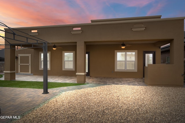 rear view of property with a patio, a ceiling fan, and stucco siding