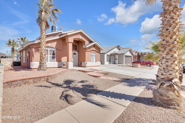 view of front facade featuring stucco siding, driveway, and a garage