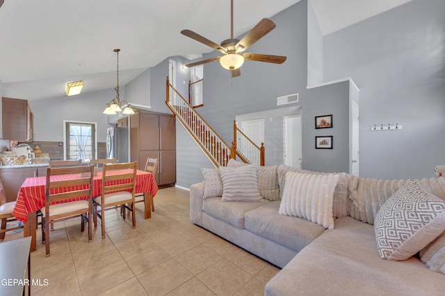 living room featuring visible vents, high vaulted ceiling, ceiling fan with notable chandelier, stairway, and light tile patterned floors