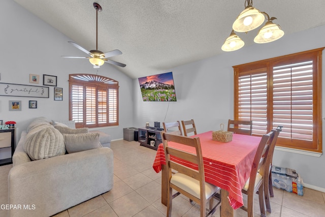 dining room with light tile patterned floors, a textured ceiling, lofted ceiling, and a ceiling fan