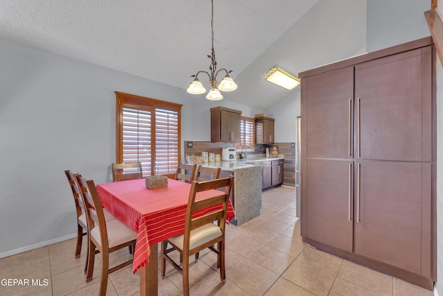 dining space with light tile patterned floors, baseboards, an inviting chandelier, vaulted ceiling, and a textured ceiling