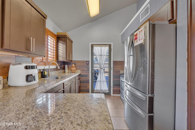 kitchen with visible vents, vaulted ceiling, light tile patterned floors, appliances with stainless steel finishes, and a sink