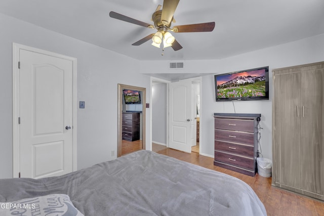 bedroom with visible vents, a ceiling fan, and wood finished floors