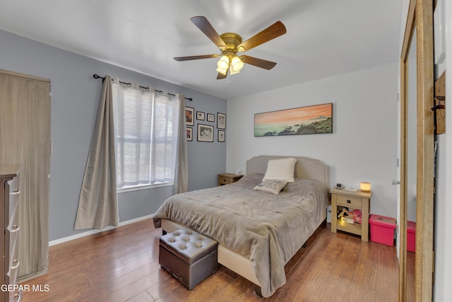 bedroom with ceiling fan, baseboards, and wood finished floors