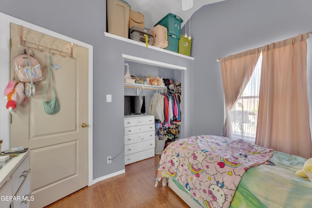 bedroom with wood finished floors and a closet