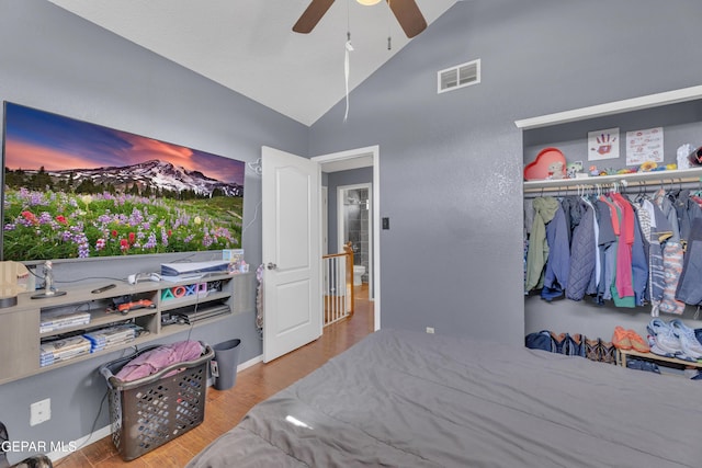 bedroom featuring visible vents, a ceiling fan, wood finished floors, a closet, and lofted ceiling