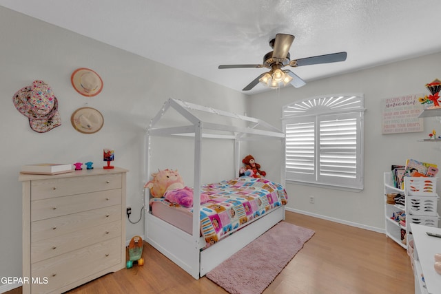 bedroom with baseboards, a ceiling fan, and light wood finished floors