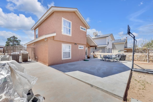 back of house with a patio, outdoor dining area, fence, and stucco siding