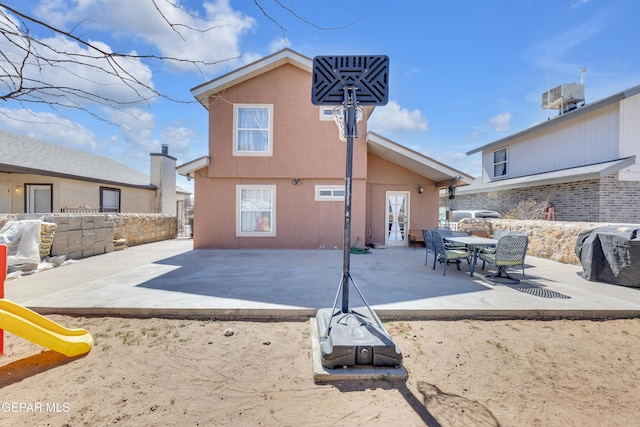 back of property featuring a patio, fence, stucco siding, french doors, and a playground