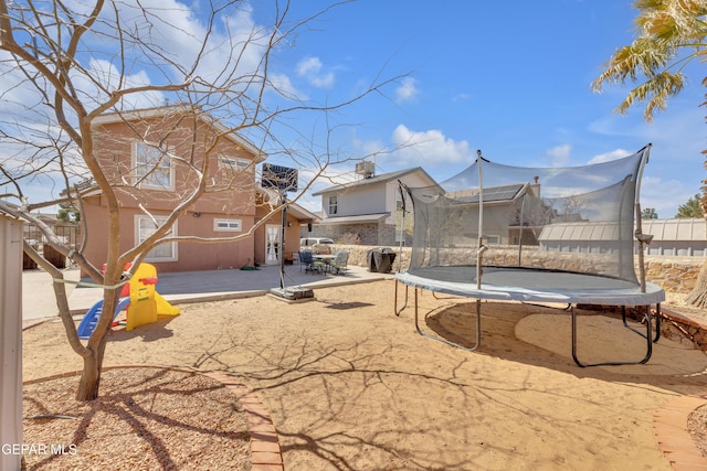 view of yard with a patio, a trampoline, and fence