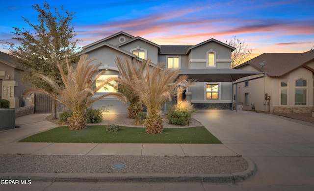 view of front of home featuring central AC unit, stone siding, driveway, and stucco siding