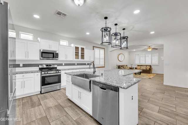 kitchen with a ceiling fan, visible vents, a sink, appliances with stainless steel finishes, and open floor plan