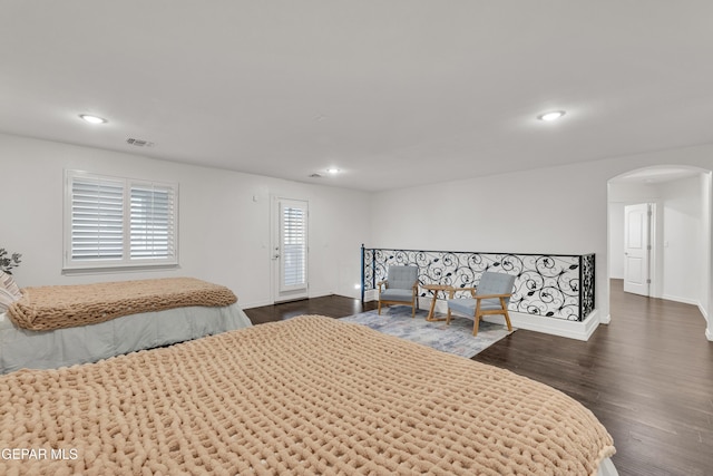 bedroom with arched walkways, visible vents, recessed lighting, and dark wood-style flooring