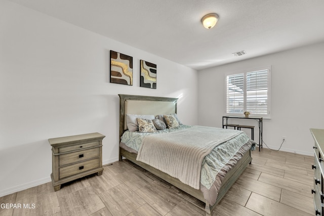 bedroom featuring light wood-style flooring, baseboards, and visible vents