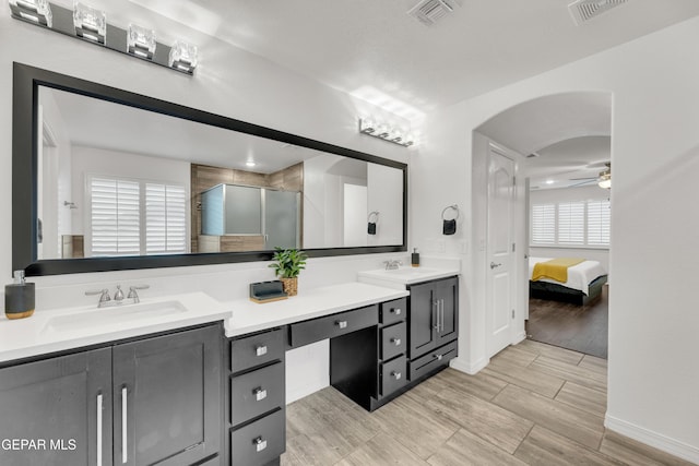 bathroom with double vanity, a stall shower, visible vents, and a sink