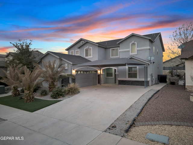 traditional home featuring stucco siding, driveway, and an attached garage