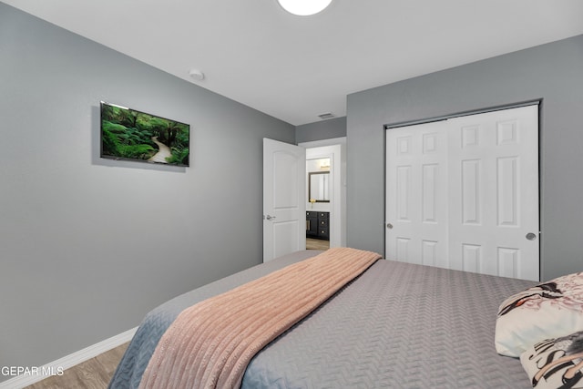 bedroom with a closet, baseboards, light wood-style floors, and visible vents