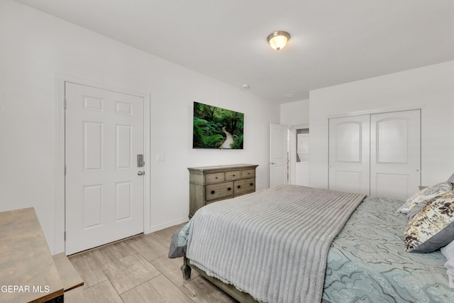 bedroom with light wood-style floors and a closet